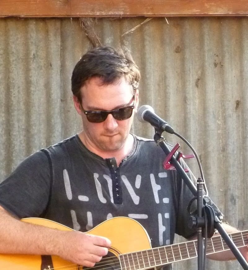 Dean Betts playing acoustic guitar